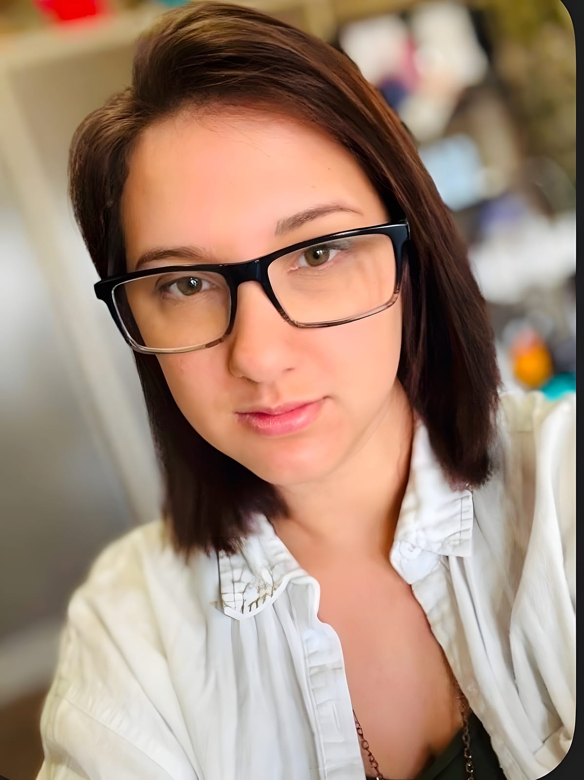 Team member with dark hair and glasses in a white shirt